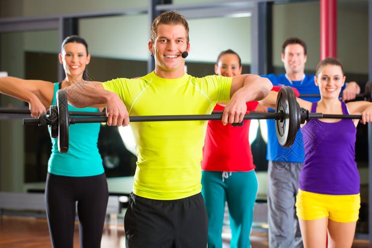 一群年轻的体育人在健身房用杠铃训练以提高身体素质