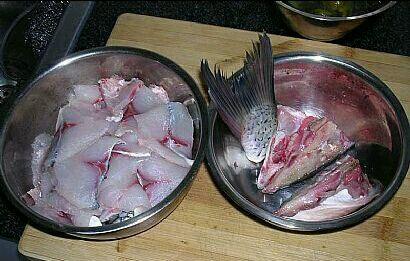 开始片鱼片,将鱼肉皮朝下至于案板上,菜刀按