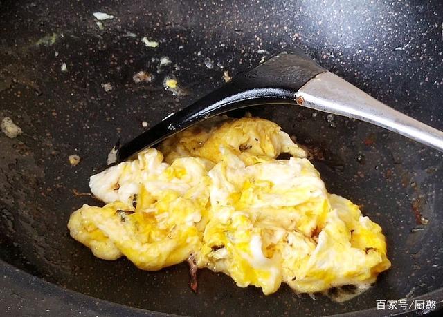 3, 炒锅里面加入适量的食用油烧热,把鸡蛋搅打散了以后倒进锅里面,把